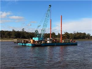 Pontón de grúa para apoyo y manejo de grúa trabajando en el río Uruguay