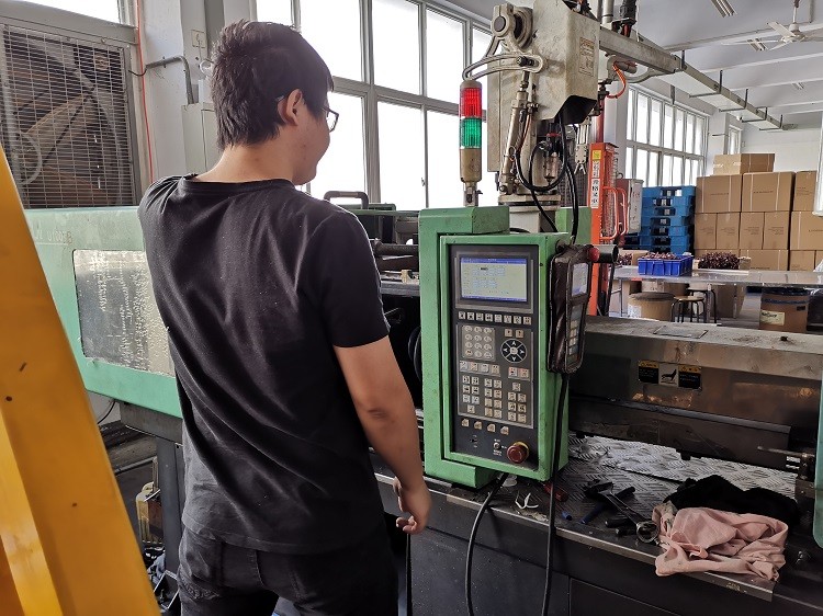 El técnico del taller de cinta de hilo de ptfe depura la máquina