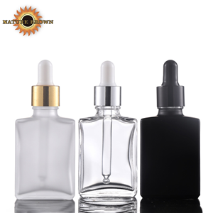 Clear square glass dropper bottle with gold metal collar and white pipette dropper shown assembled and disassembled for premium serum packaging