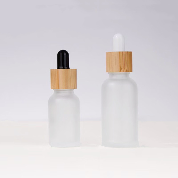 Botol penetes kaca buram dengan tutup bambu ukuran 0,5oz dan 1oz untuk kemasan minyak esensial perawatan kulit.
