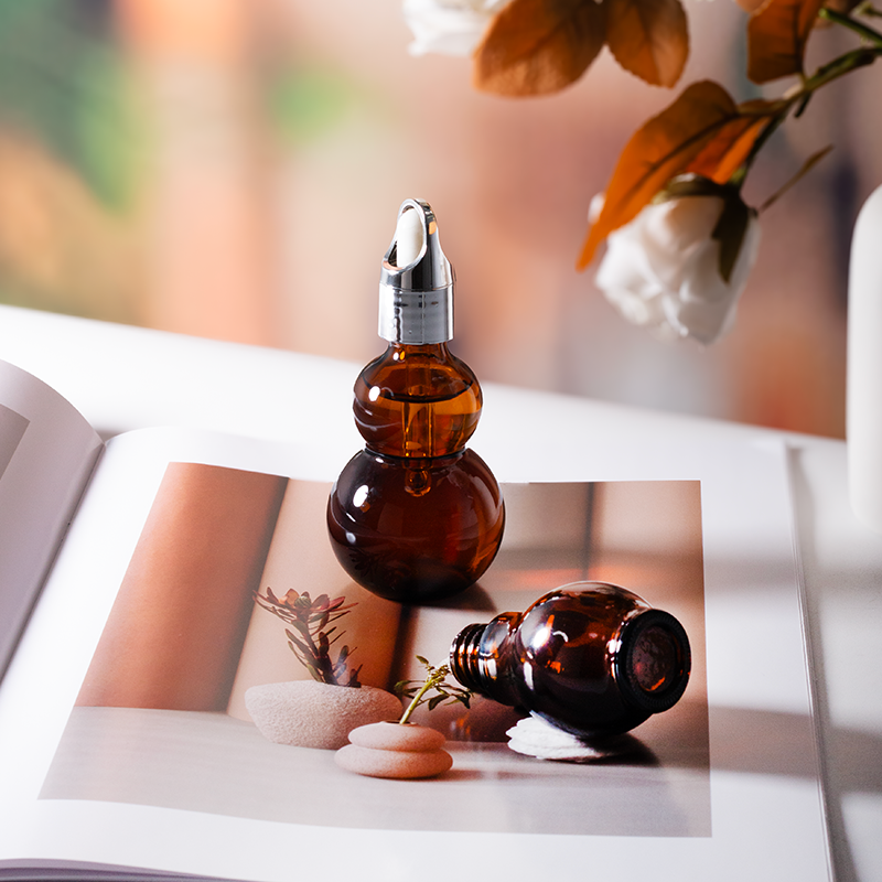 Dark brown glass bottle with gold dropper