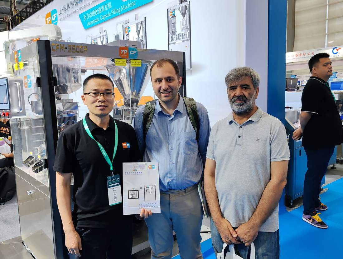 Visitors discussing the CFM-3500B automatic capsule filling machine at Booth 8D06
