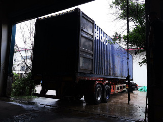 Încărcarea containerului în interiorul atelierului în ziua ploioasă