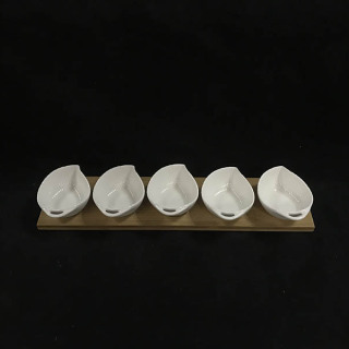 Weiße Keramikschale mit Serviertablett aus Bambusholz für die Küche