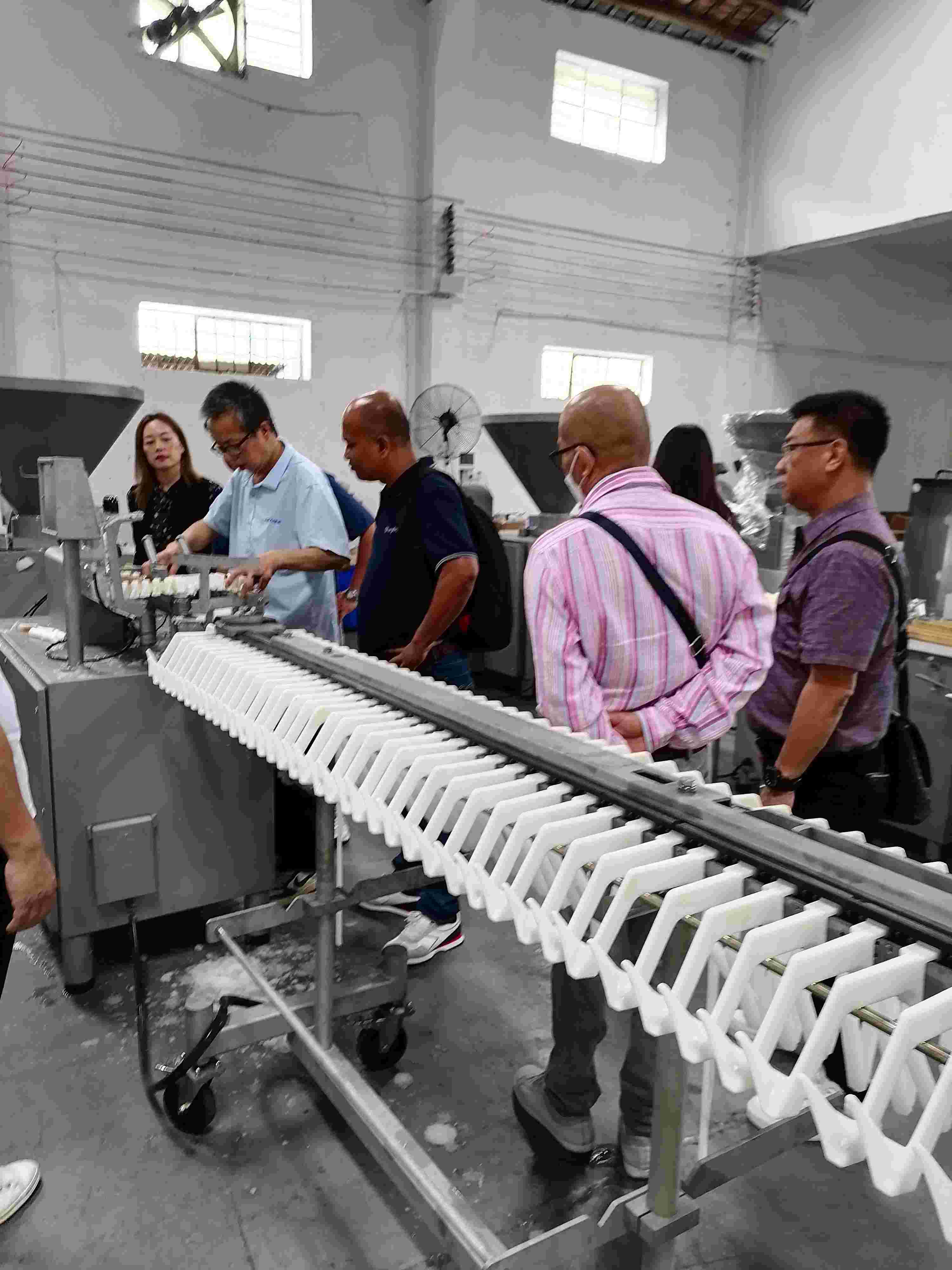 Visite d'un client thaïlandais chez Foshan Aokai Machinery Technology Co., Ltd. pour une ligne de production de saucisses torsadées et une formation sur les produits