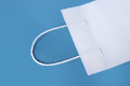 Weißbraune Einkaufstasche aus Kraftpapier, kundenspezifische Kraftpapiertüte mit flachem Griff für Kleidung, Schuhe, Lebensmittelgeschäft