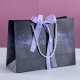 Bolsa de transporte de papel de compras púrpura de joyería de lujo con impresión personalizada al por mayor con asas de lazo de cinta embalaje de bolsa de regalo impreso con logotipo