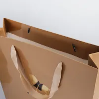Recyclable haut de gamme doux laminage embross logo produit de luxe brun artisanat petit shopping papier cadeau sacs ruban poignées