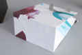 Boutique européenne colorant des sacs à provisions en papier de maquillage de toilette cosmétique avec poignée en ruban