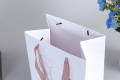 Shopping bag in carta euro bianca lucida di lusso medio riciclabile con manico in corda viola fantasia con logo
