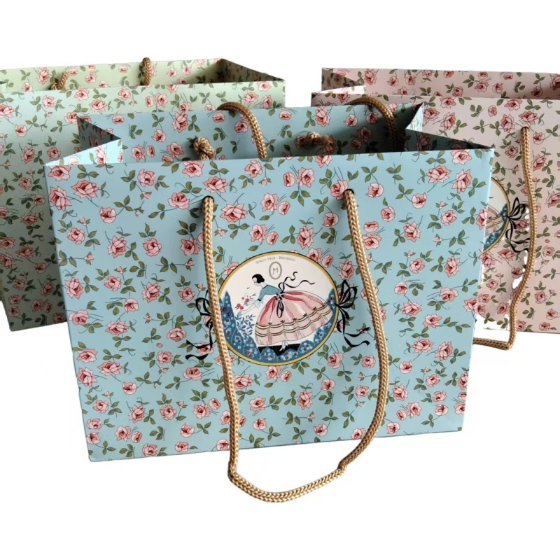 Individuell gestaltete, luxuriöse Geschenktüten aus Papier mit floralem Muster und geknoteten Seilgriffen