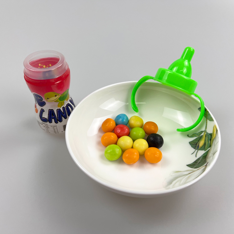 Feeding bottle with nipple shaped sweet fruity multicolored hard candy