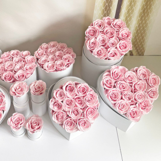 Rose stabilizzate di diverse dimensioni in una scatola a cuore