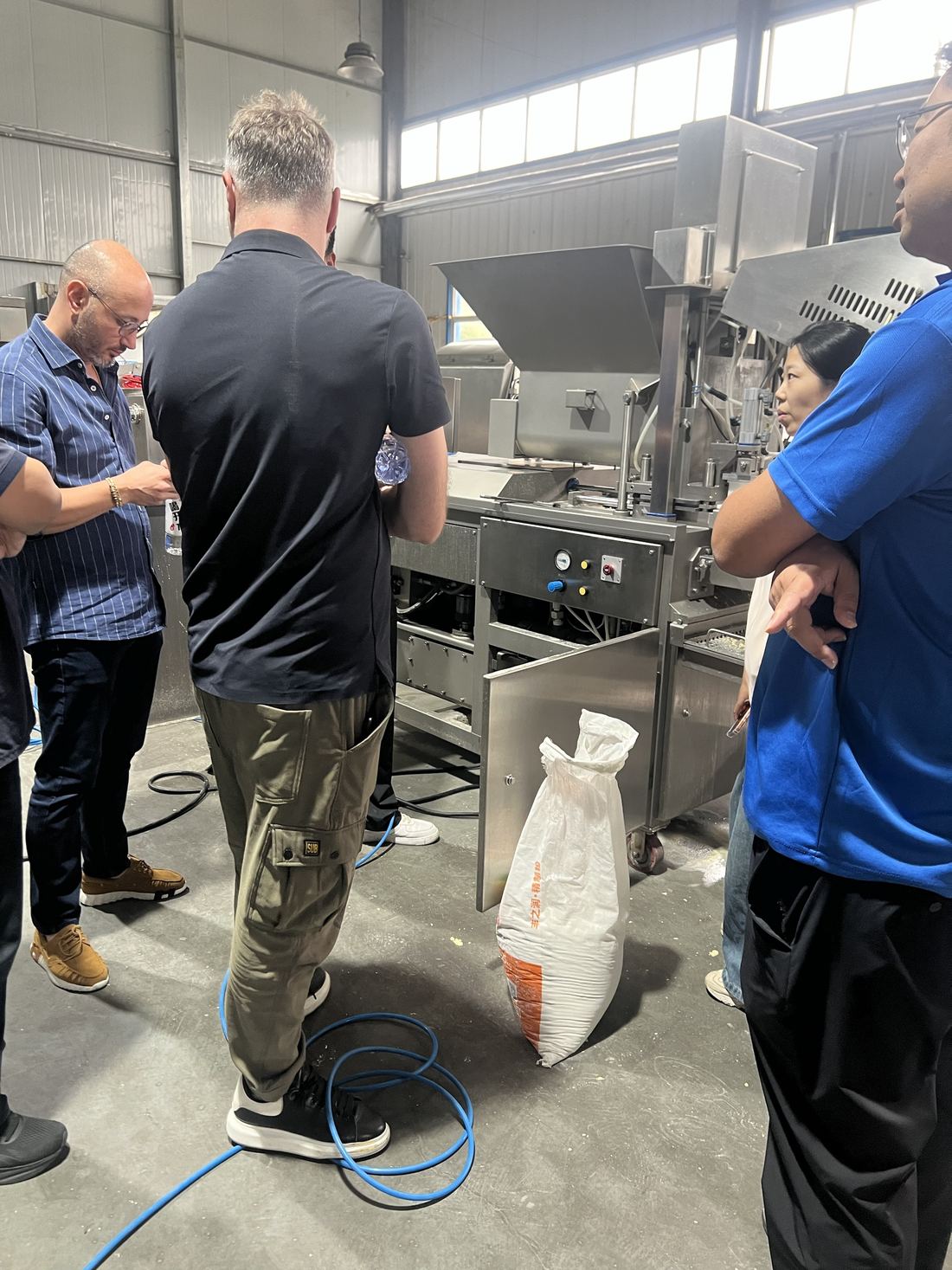 Visitors examining the breading machine alongside the forming machine
