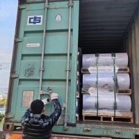 Rouleaux de PET géants empilés horizontalement soigneusement sur des palettes