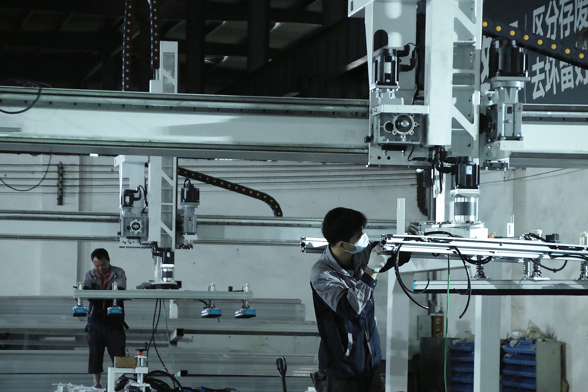 Workers are assembling and installing an automatic loading and unloading machine.