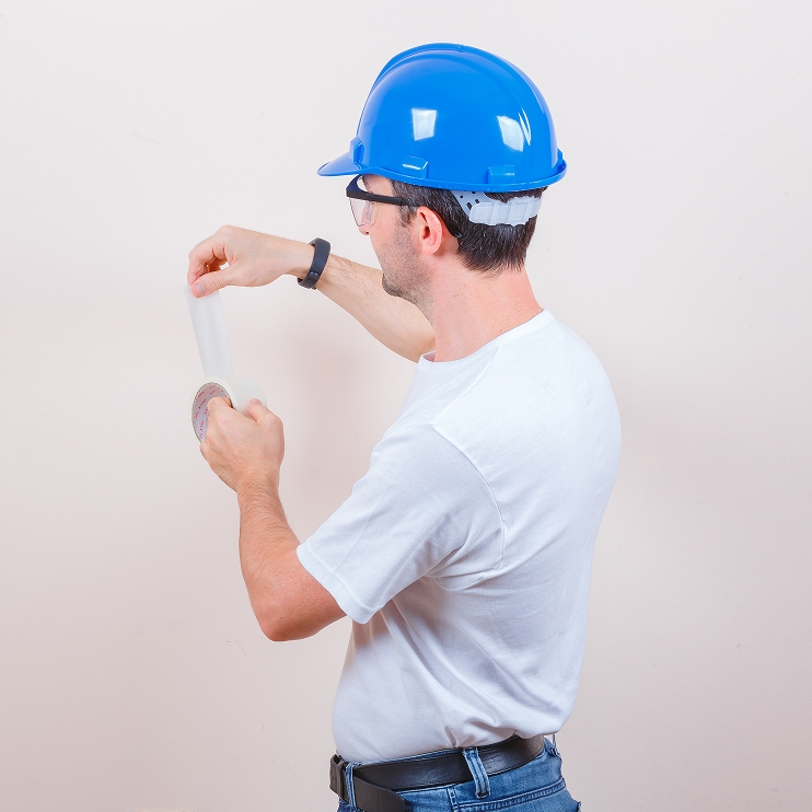 Crop Man Protecting Floor with Sheet