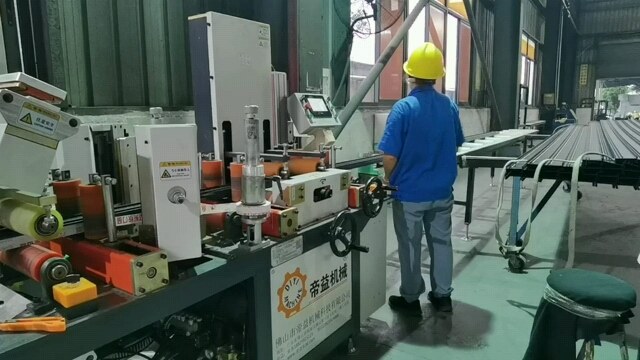 图6|贴膜与切膜工位实拍。观察膜层贴合、两支型材之间的分离以及端部覆盖位置。
